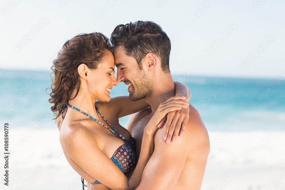 Happy couple hugging on the beach 