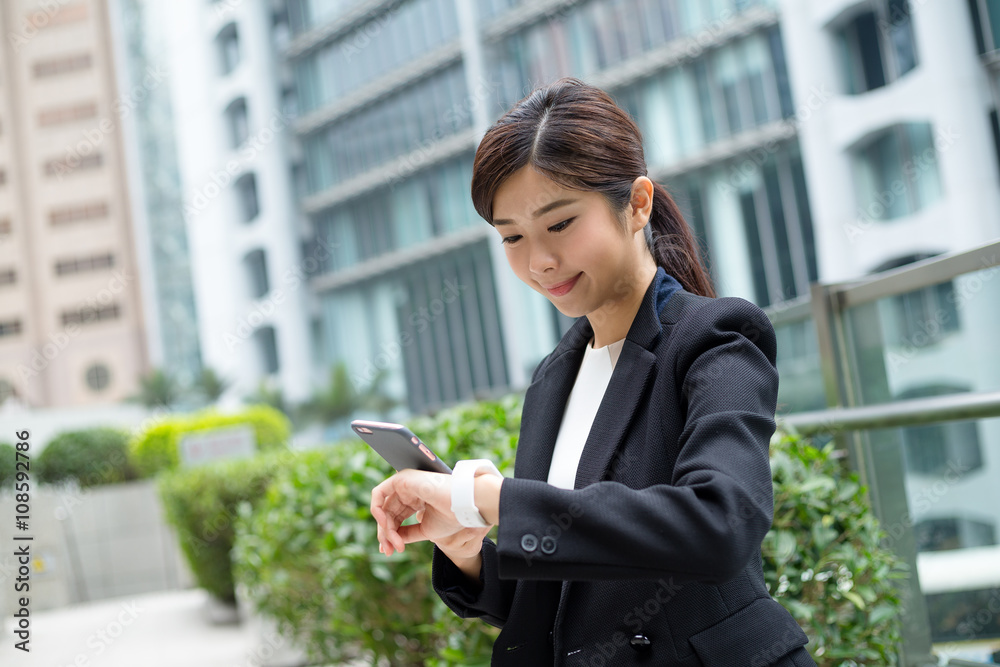 Businesswoman use of mobile phone and smart watch Businesswoman use of mobile phone and smart watch