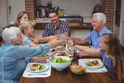 Multi generation family toasting drink while celebrating thanksg