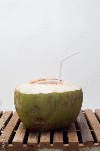 Young coconut on wooden table.