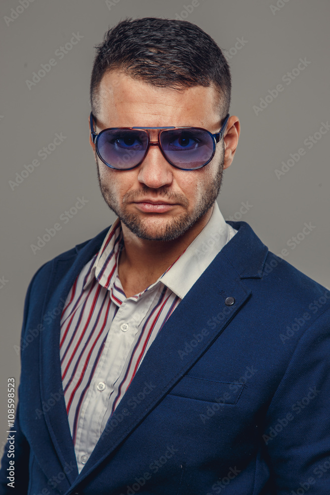 A man in a suit and sunglasses. A man in a suit and sunglasses.