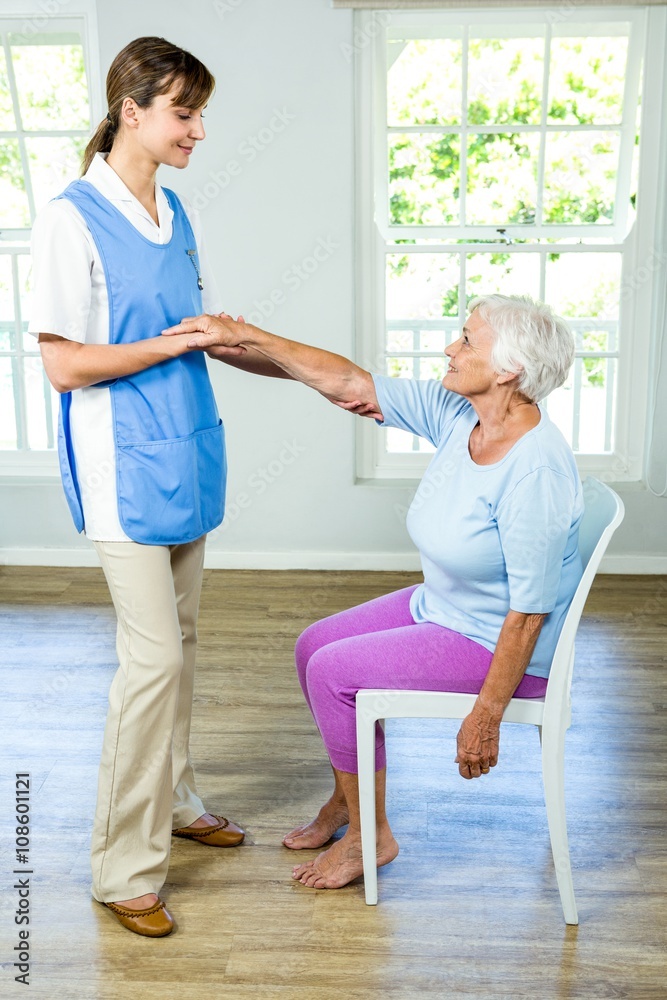 Senior woman stretching hand with nurse Senior woman stretching hand with nurse