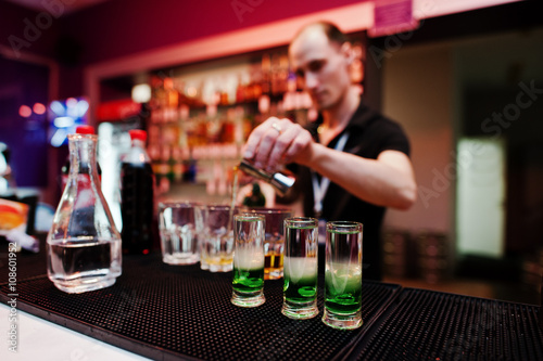 Barman preparing green mexican cocktail drink at the bar