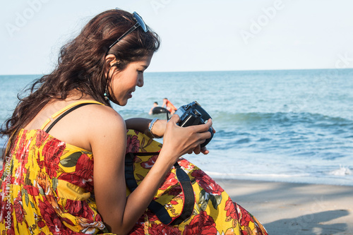 Happy women looking piture in camera at the beach photo