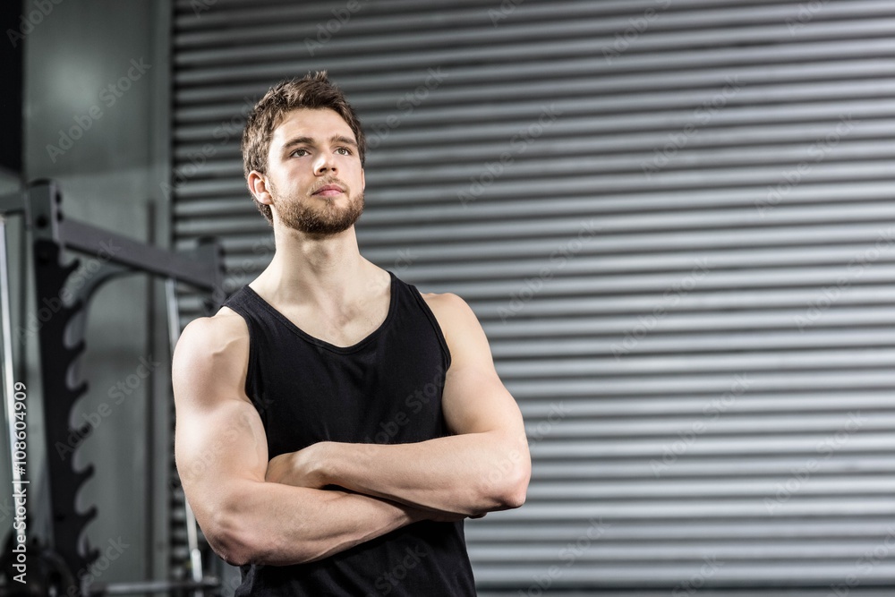 Naklejka premium Thoughtful fit man with crossed arms