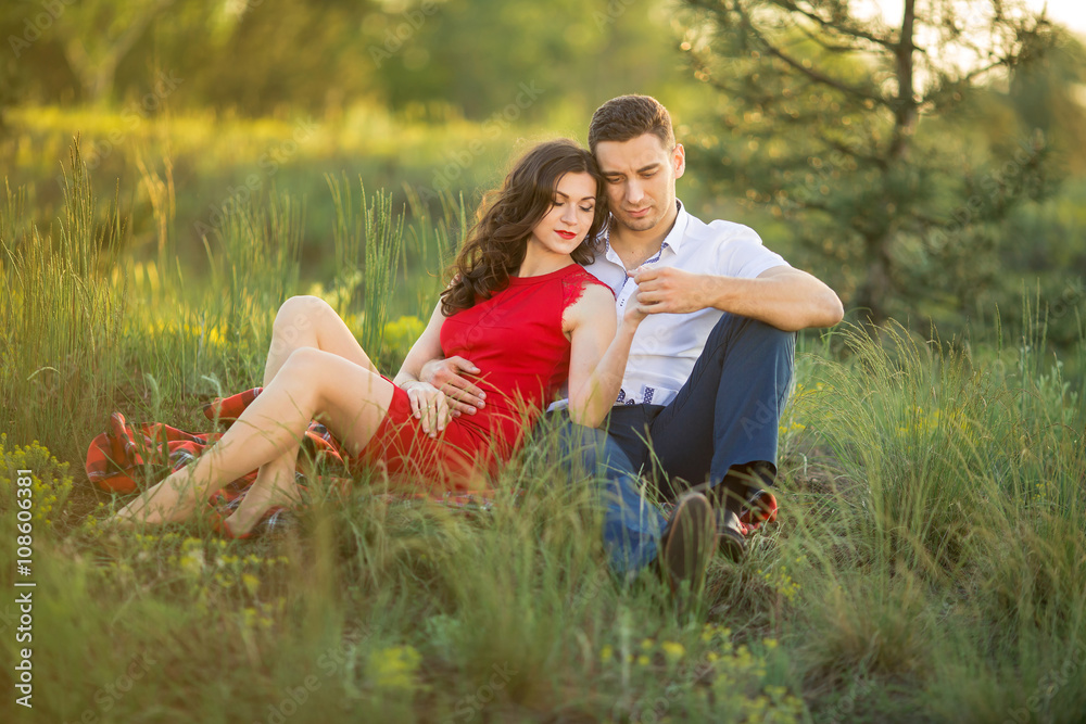Happy couple resting on grass in park Happy couple resting on grass in park