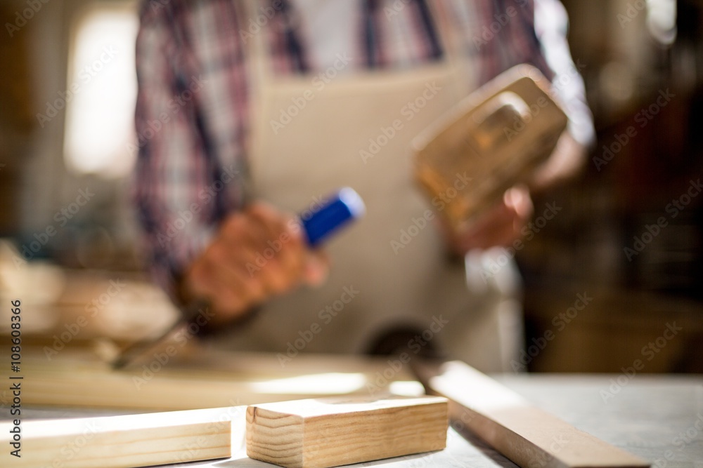 Close-up of carpenter working on wooden plank on workbench Close-up of carpenter working on wooden plank on workbench