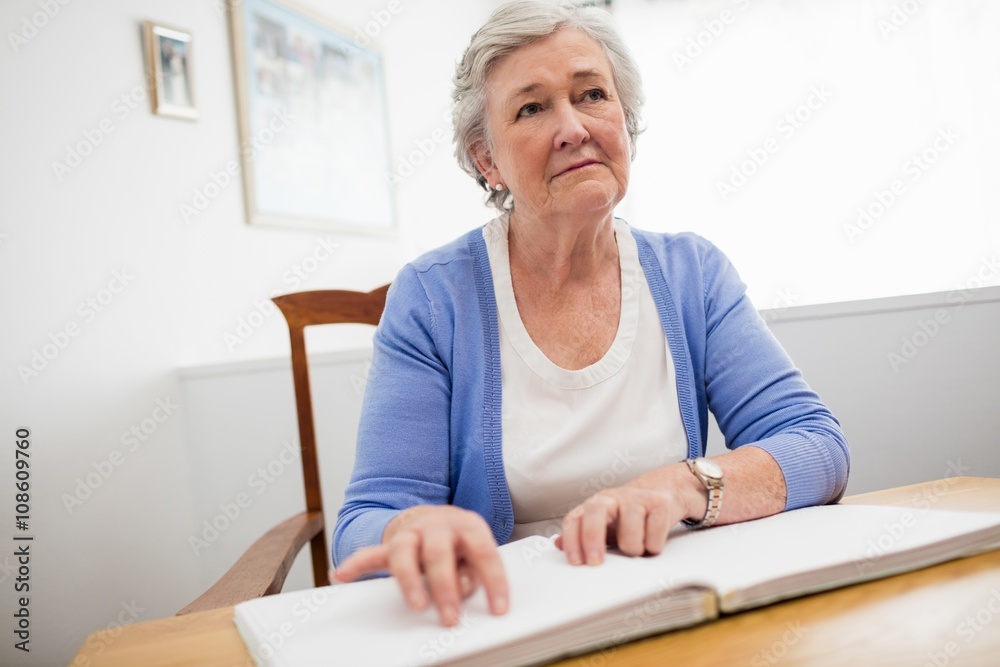 Blind senior woman using braille to read Blind senior woman using braille to read