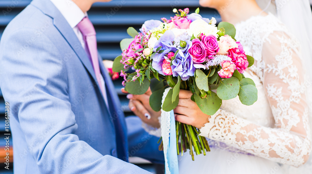 Wedding flowers ,Woman holding colorful bouquet with her hands on wedding day Wedding flowers ,Woman holding colorful bouquet with her hands on wedding day