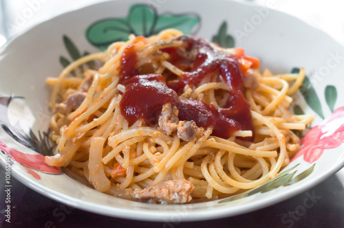 Fried spaghetti and pork with tomato source in plate