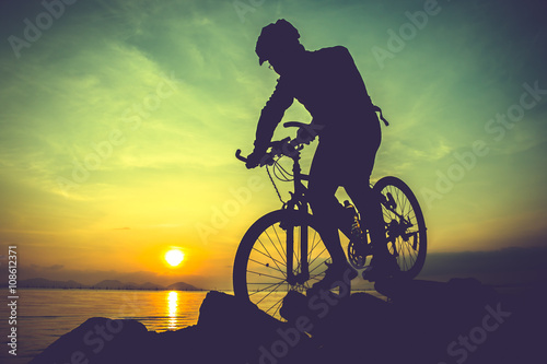 Fototapeta Naklejka Na Ścianę i Meble -  Healthy lifestyle. Silhouette of bicyclist riding the bike at seaside