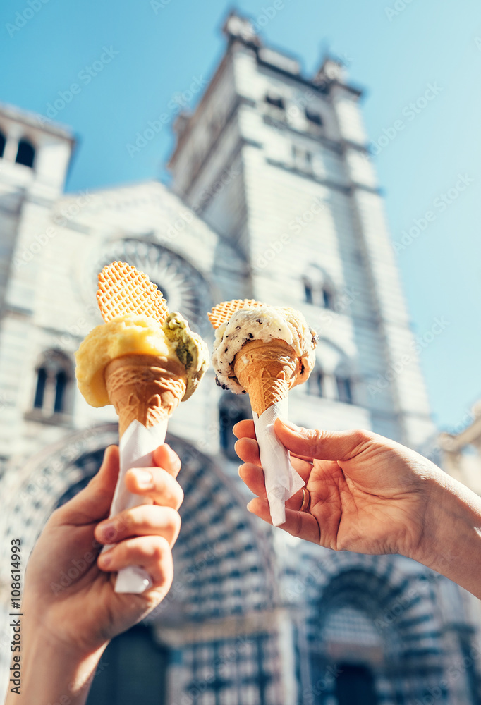 Fototapeta premium Two hands with ice cream on the San Lorenco Cathedral backgroun