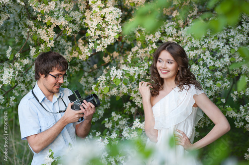 The man photographs and young girl in a garden