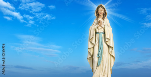 Statue of the Virgin Mary against blue sky