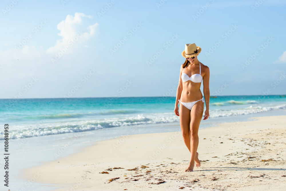 Relaxed woman in bikini enjoying tropical beach and caribbean summer  vacation. Fit tanned brunette enjoying a walk by the sea at Playa Paraiso,  Riviera Maya, Mexico. foto de Stock | Adobe Stock