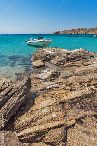 Small boat in Paranga Beach on the island of Mykonos, Cyclades, Greece photo