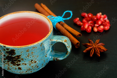 Red Tea with beautiful cup, decorated with cinnamon and pomegran photo