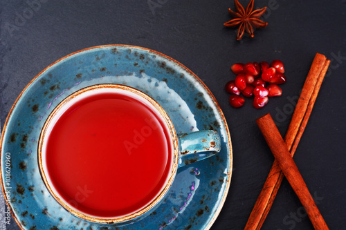 Red Tea with beautiful cup, decorated with cinnamon and pomegran photo