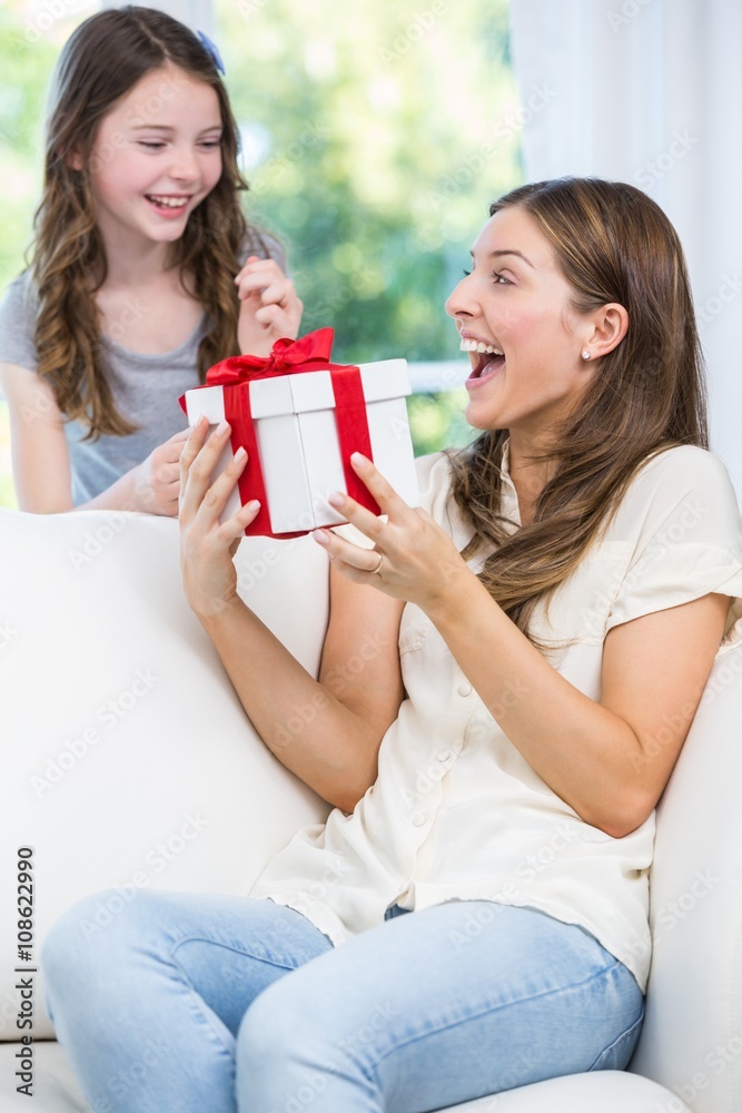 Surprised woman holding gift with daughter