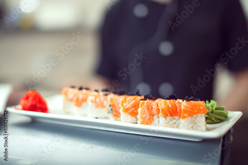 male cooks preparing sushi in the restaurant kitchen.