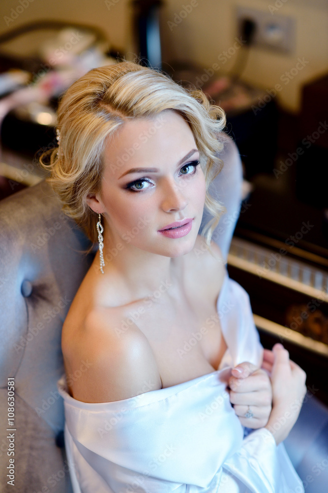 Beauty bride in dressing gown with bridal makeup indoors. Beautiful model girl in colorful wedding robe. Female portrait of cute lady. Woman with hairstyle