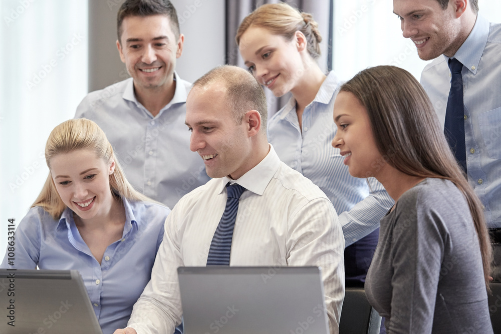 smiling business people with laptop computer