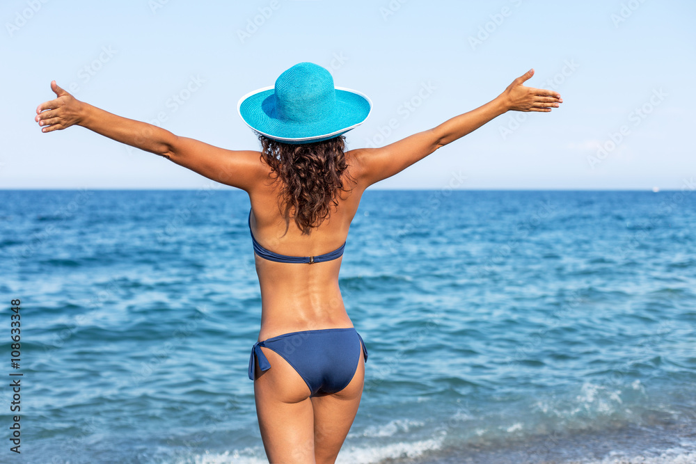 Woman enjoying warm summer day at the seaside.