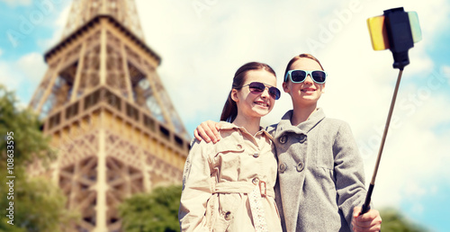 girls with smartphone selfie stick at eiffel tower