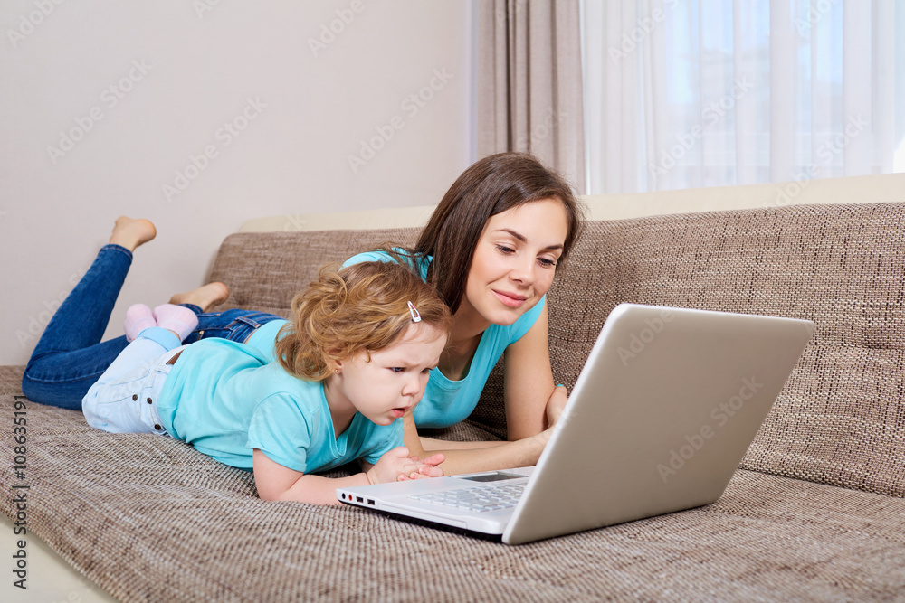 Mother and her daughter looking at laptop at home Mother and her daughter looking at laptop at home
