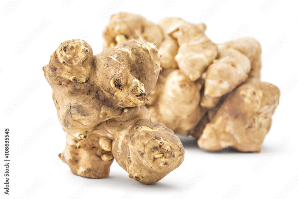 Pile of fresh raw Jerusalem artichoke, one in front, isolated on white background Pile of fresh raw Jerusalem artichoke, one in front, isolated on white background