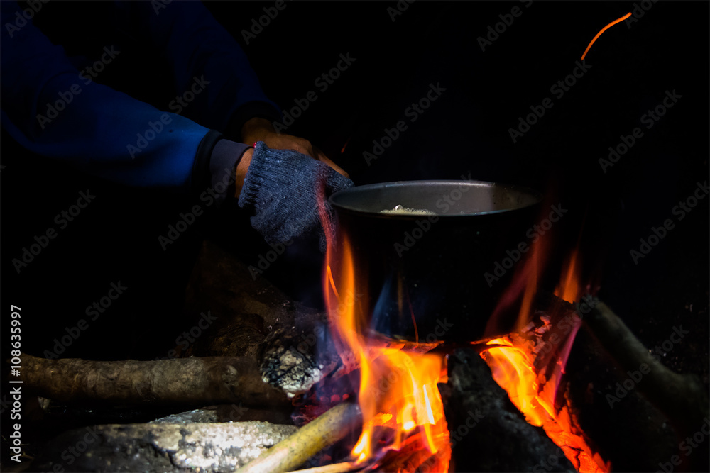 Cooking by using a pot and bonfire at night camping. Cooking by using a pot and bonfire at night camping.
