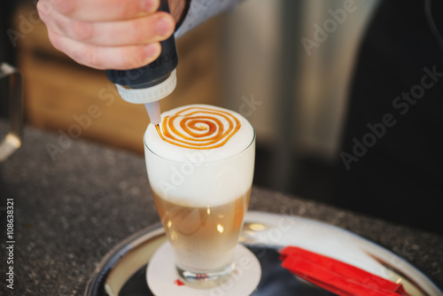 Barista creates a picture in a cup of coffee latte