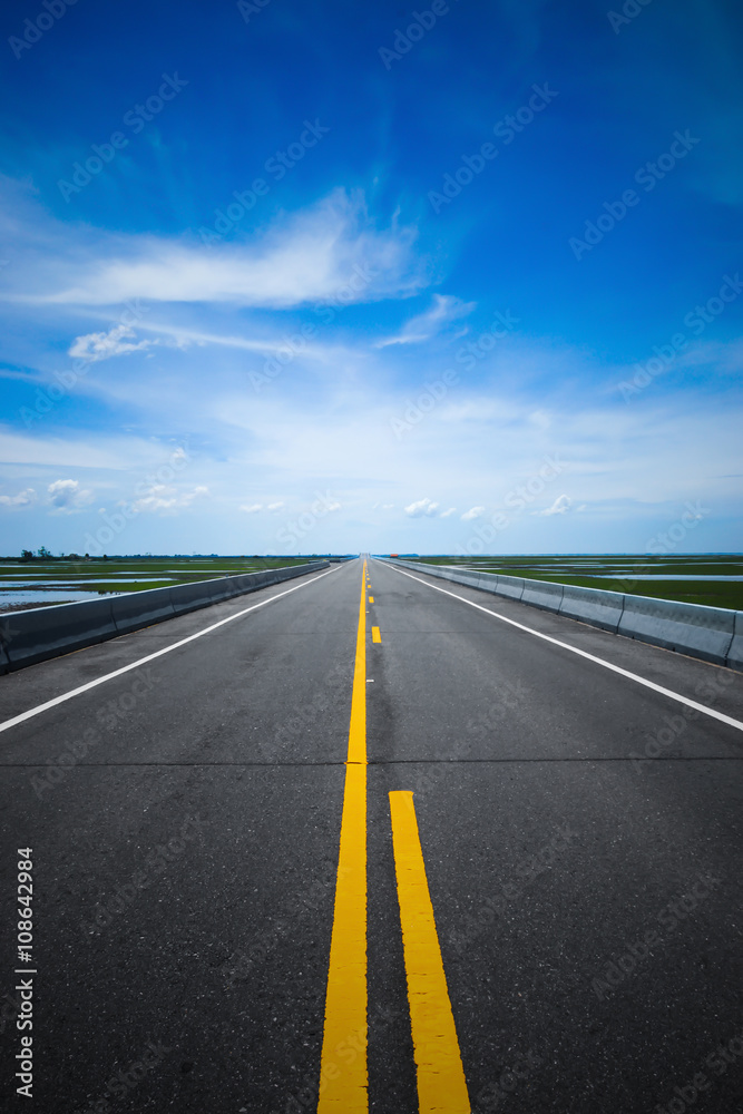 Empty road and the yellow traffic lines with blue sky. Empty road and the yellow traffic lines with blue sky.