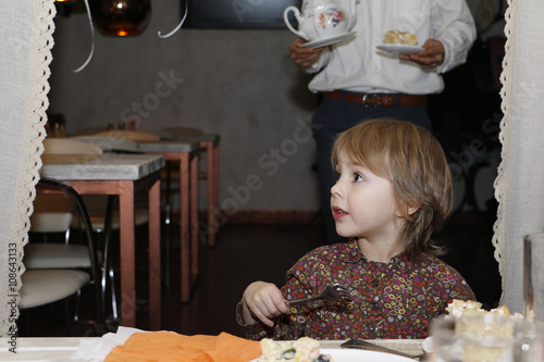 Beautiful little girl with big brown eyes in the cafe