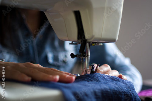 Closeup of a woman using a sewing machine photo