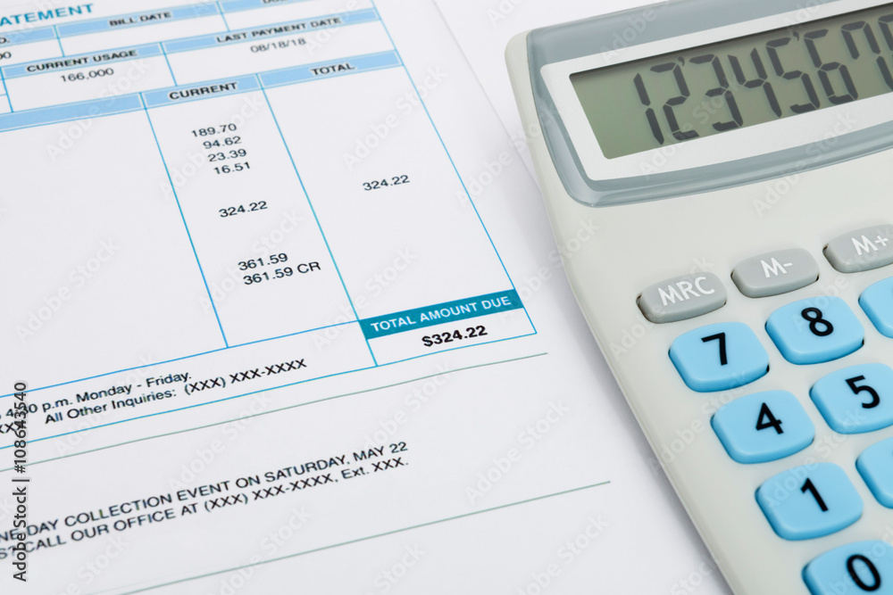 Unpaid utility bill and calculator over it Unpaid utility bill and calculator over it