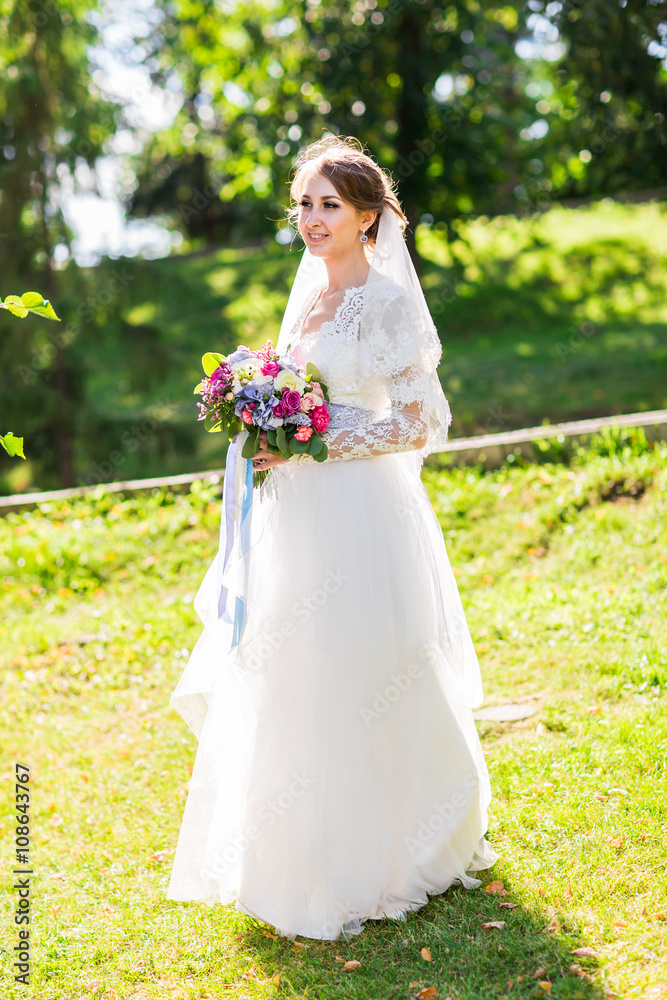 Young bride in wedding dress holding bouquet
