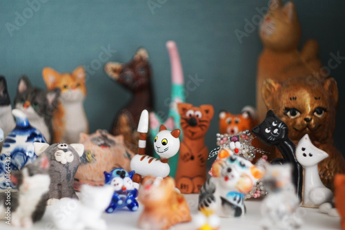 A collection of figurines of cats and cats from different countries and cities on the shelf. The cats brought from travel