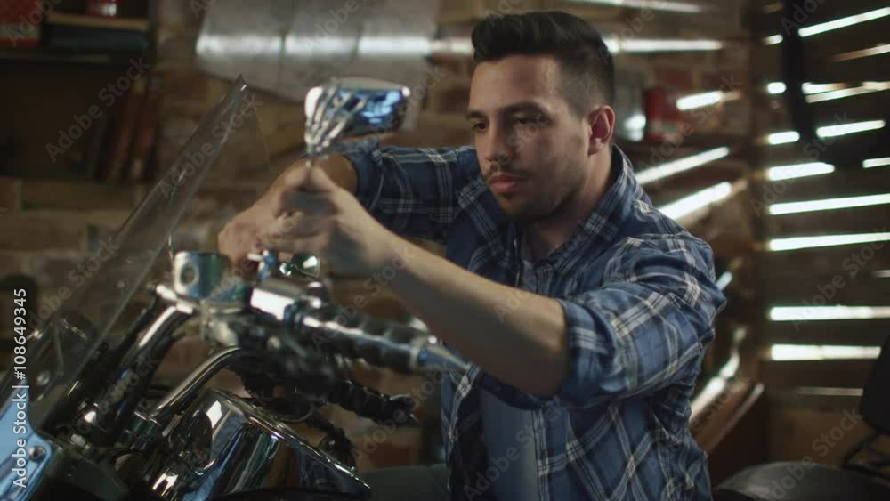 Man is tightening nuts with a spanner and repairing his motorcycle in a garage. Shot on RED Cinema Camera. Man is tightening nuts with a spanner and repairing his motorcycle in a garage. Shot on RED Cinema Camera.