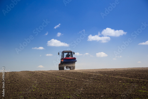 Tractor Spaying a field in the spring accompanied