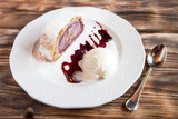 Cherry strudel cake served with ice cream on wooden table at res