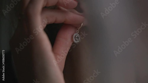 The young woman puts on beautiful earrings