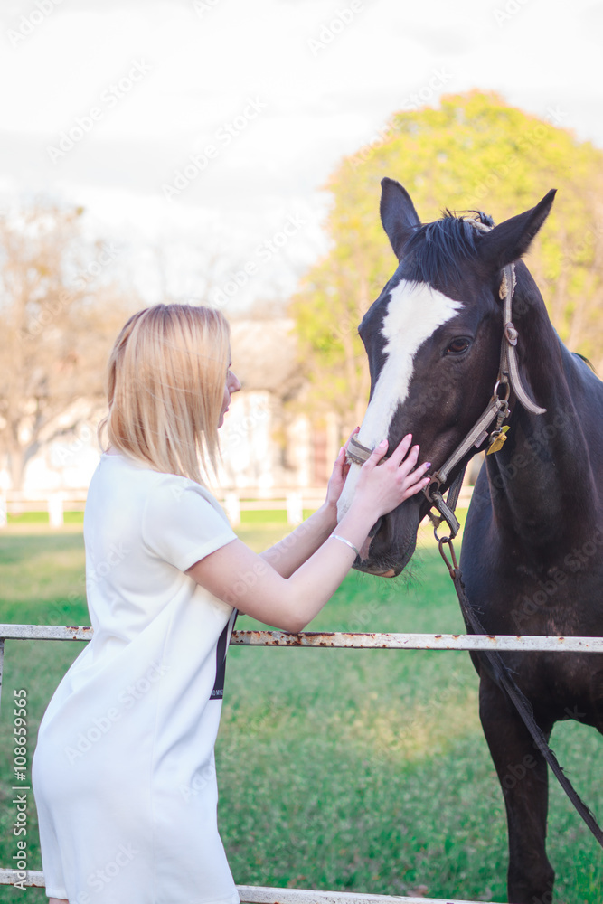 Obraz premium young woman petting a beautiful horse
