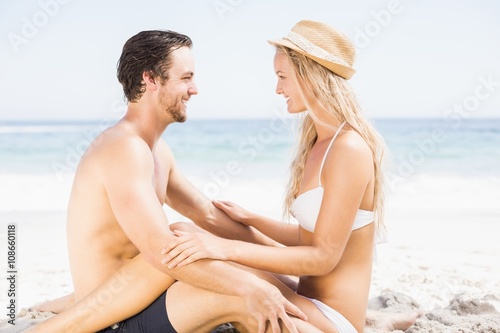 Young couple sitting face to face on the beach