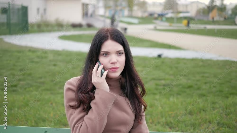 Girl sitting on a bench and talking on the phone