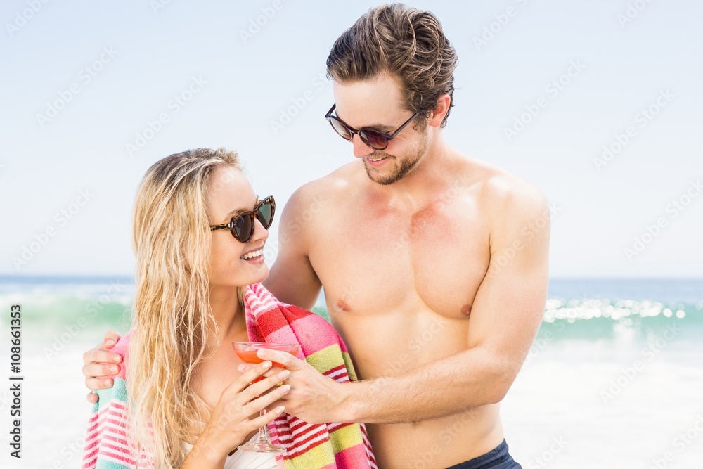 Young couple in sunglasses embracing on the beach Young couple in sunglasses embracing on the beach
