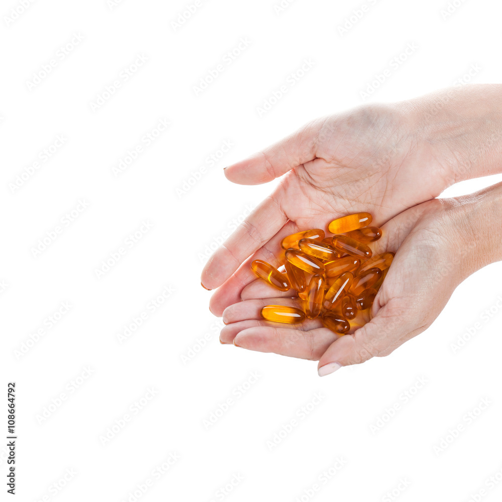 Soft gels pills with Omega-3 oil in hand closeup on white Soft gels pills with Omega-3 oil in hand closeup on white