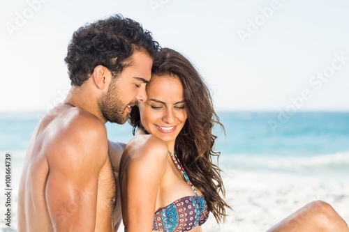 Happy couple sitting on the beach 