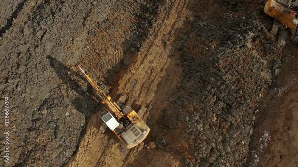 Aerial shot of excavators digging the ground, level the soil Aerial shot of excavators digging the ground, level the soil