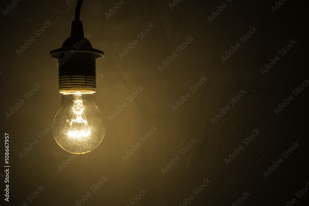 old lightbulb against a grunge concrete wall